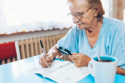 Senior resident working on a crossword puzzle indoors
