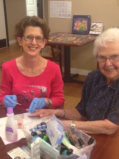 Resident receiving manicure with staff assistance