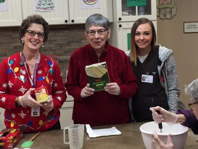 Residents and staff baking in a cheerful kitchen.