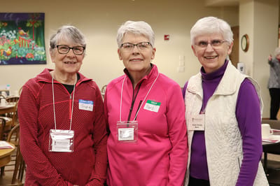 Three volunteers smiling in a community space