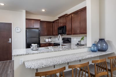 Modern kitchen with granite countertop and wooden stools