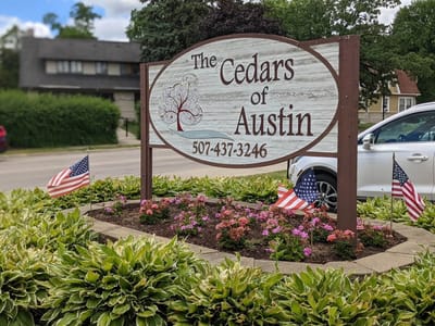 Welcome sign for The Cedars of Austin with flowers