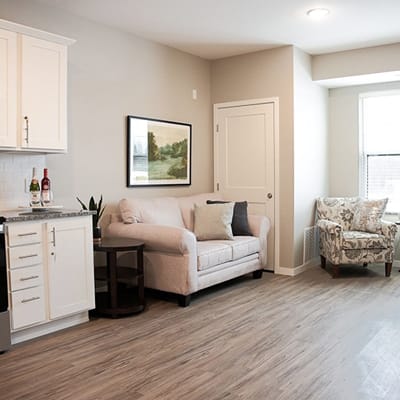 A cozy resident living area with a couch and art on the wall