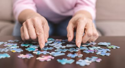 Hands of a resident assembling a jigsaw puzzle