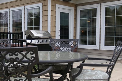 Outdoor patio area with a grill and seating