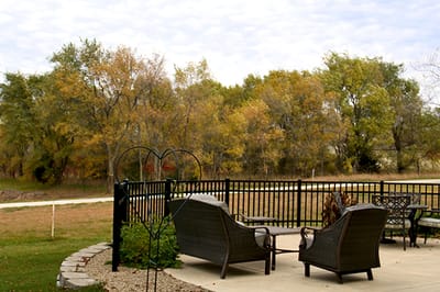Outdoor seating area with fall foliage in the background