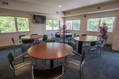 Bright common area with round tables and flowers