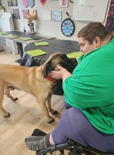 Resident interacting with a dog in an activity room