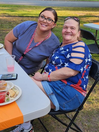 Resident and staff member enjoying a meal outdoors