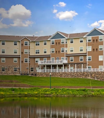 Exterior view of Polar Ridge Senior Living building by the water