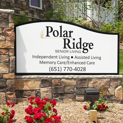 Sign for Polar Ridge Senior Living with flower beds