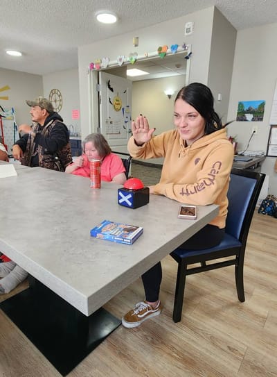 Staff member playing a game with residents in an activity room