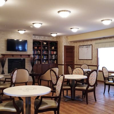 Bright common area with tables and chairs for residents