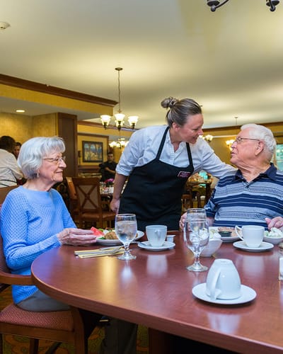 Residents dining together with staff assistance