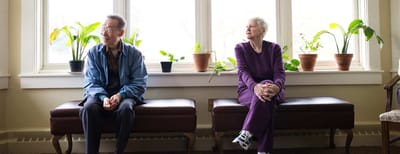 Residents sitting in a common area with plants