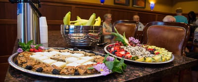 A variety of desserts and fruits displayed in a dining area