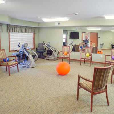 A bright activity room with exercise equipment and balls