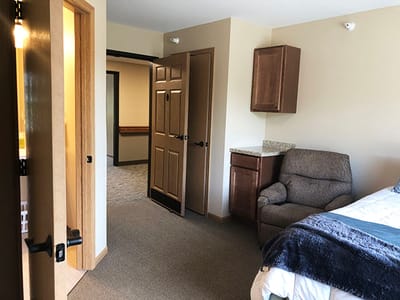 A well-furnished interior room with a chair and bed