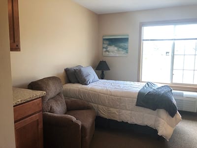 Cozy private room with bed and armchair
