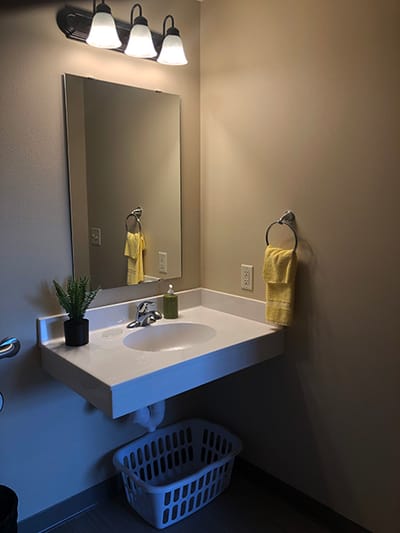Well-lit bathroom sink area with towels