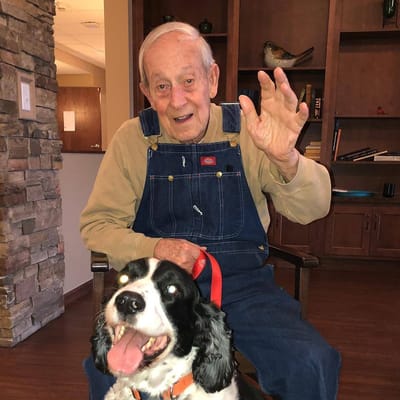 A resident happily interacting with a dog in a cozy room