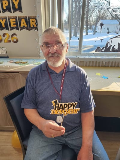 Resident celebrating New Year's with a festive sign