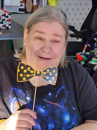 Resident smiling with a decorative bow tie