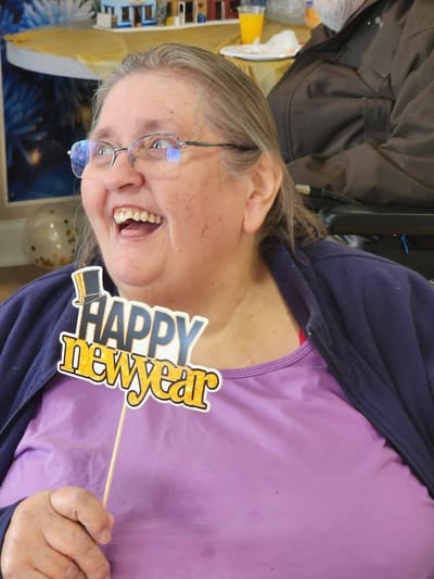 Resident celebrating New Year with a festive sign