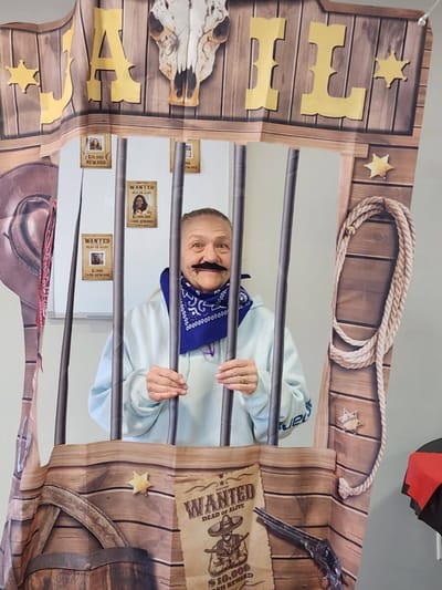 Resident posing in a fun jail-themed photo booth