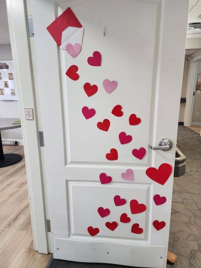 Decorated door covered with heart-shaped paper cutouts