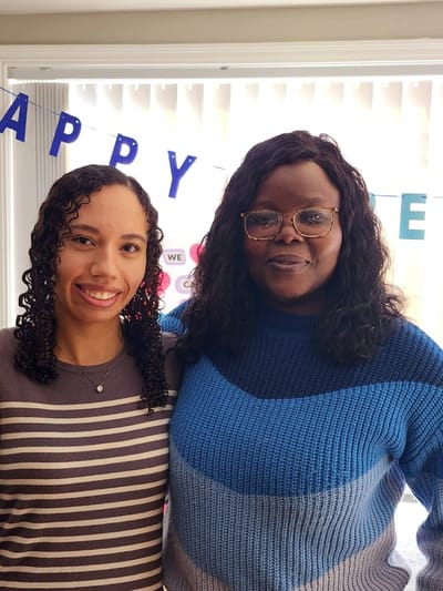 Two staff members celebrating with a banner in the background