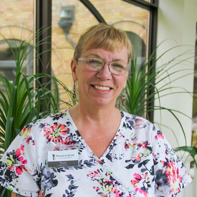 Staff member smiling in a bright interior setting