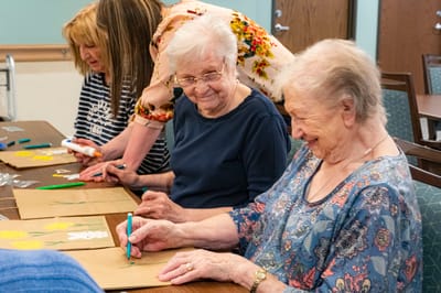 Seniors engaged in a craft activity at a table