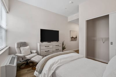 A cozy private resident room with a bed and TV
