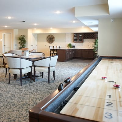 Common area with seating and game table in a senior living facility