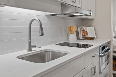 Modern kitchen area with white cabinetry and sink