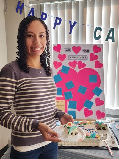 Staff celebrating caregivers with cake and decorations