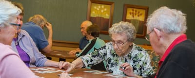 Residents playing a card game in a common area