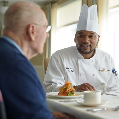 Chef interacting with a resident during meal service