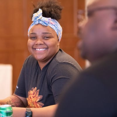 A smiling staff member engaging with another person