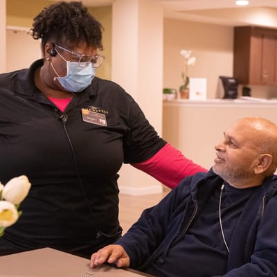 Staff member interacting with a resident in a warm setting