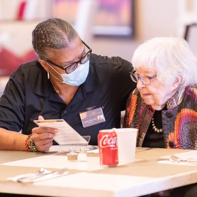 Staff assisting a resident with the menu in the dining room
