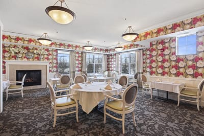 Bright dining room with floral wallpaper and dining tables