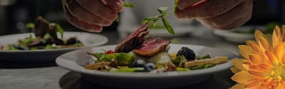 Chef garnishing a plated gourmet meal