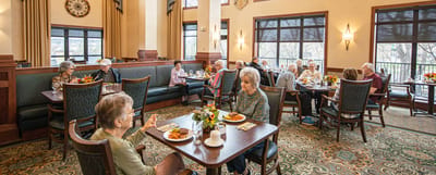 Residents enjoying meals in a dining area with bright decor