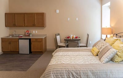Cozy resident room with kitchenette and dining setup