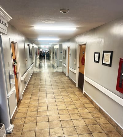 Clean hallway with resident doors and activities happening in the background.