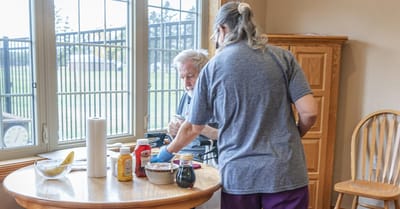 Staff assisting a resident with food preparation