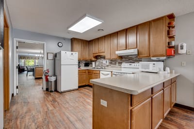Facility kitchen with modern appliances and wooden cabinets