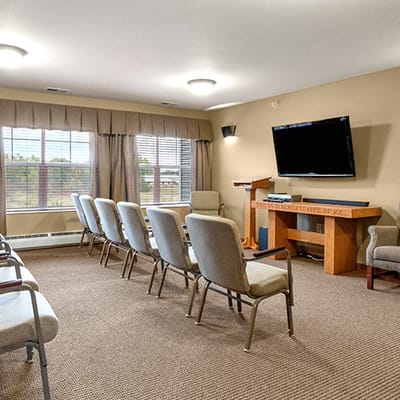 Interior activity room with seating and a large screen